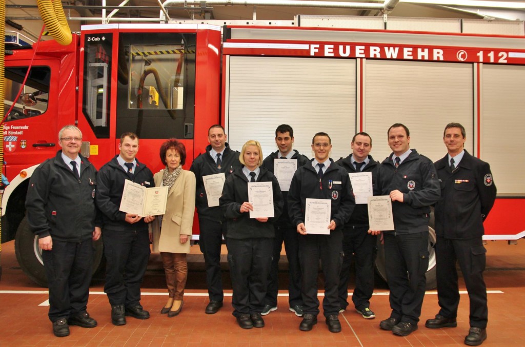 Gruppenbild vor dem neuen Hilfeleistungs-Löschgruppenfahrzeug HLF 20 in der Fahrzeughalle mit Bürgermeisterin Barbara Schader, Wehrführer Burkhard Jakob (links), stellvertretendem Wehrführer Simon Lambrecht, die beförderten Einsatzkräften und Stadtbrandinspektor Uwe Schwara (rechts). Foto: Hannelore Nowacki