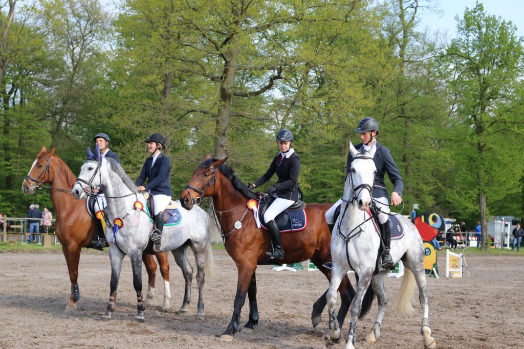 Die drei Sieger mit Schleifchen (von hinten): Axel Kumpf, Sabrina Tovarnak, Teresa Friedrich und Jan Carsten Weber vom RFV Groß-Zimmern 1949 mit der Startnummer 332 auf Larimor (5. Platz mit 69,98 Sekunden und vier Fehlern). Eine rasante Siegerrunde mit Musik folgte. Foto: Hannelore Nowacki