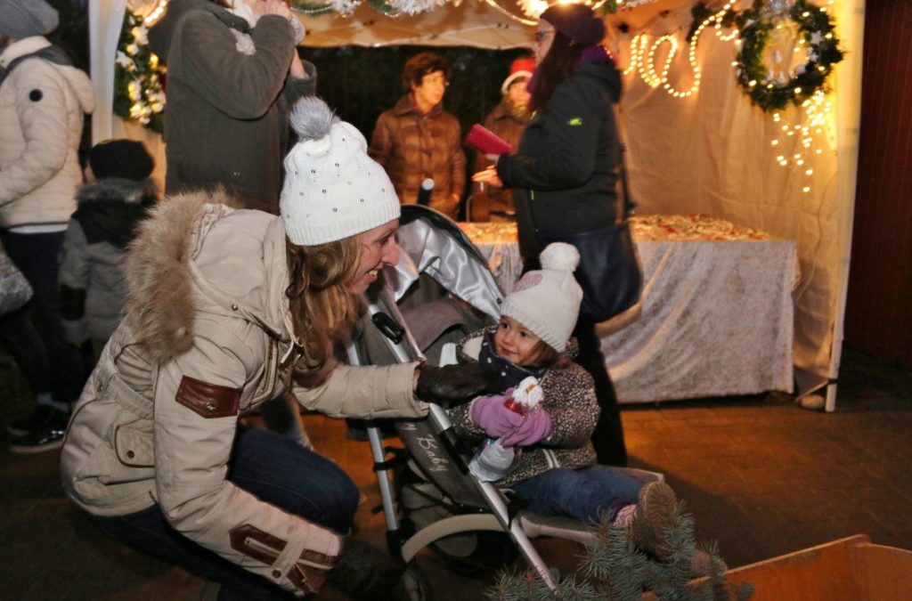 Der Nikolaus hatte der kleinen Luisa aus seinem Handwagen eine gut gefüllte Tüte überreicht – eine gelungene Überraschung, über die sich Mutter und Kind freuten. Foto: Hannelore Nowacki